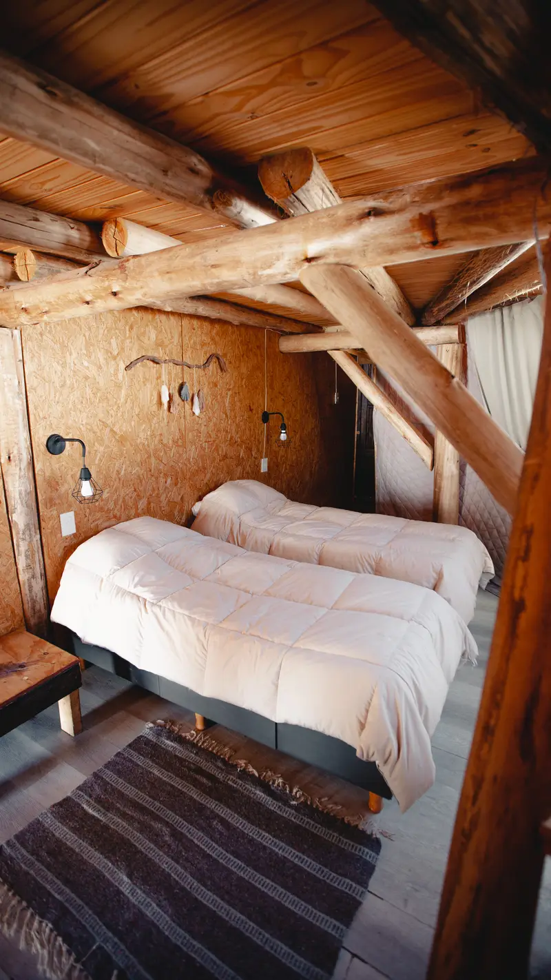 Interior del domo geodésico con camas y vigas de madera